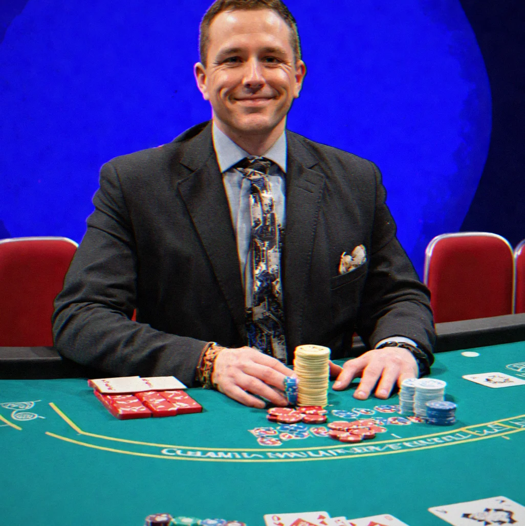 Dealer seated at tournament table with card shoe, burn pile, and button positioned correctly